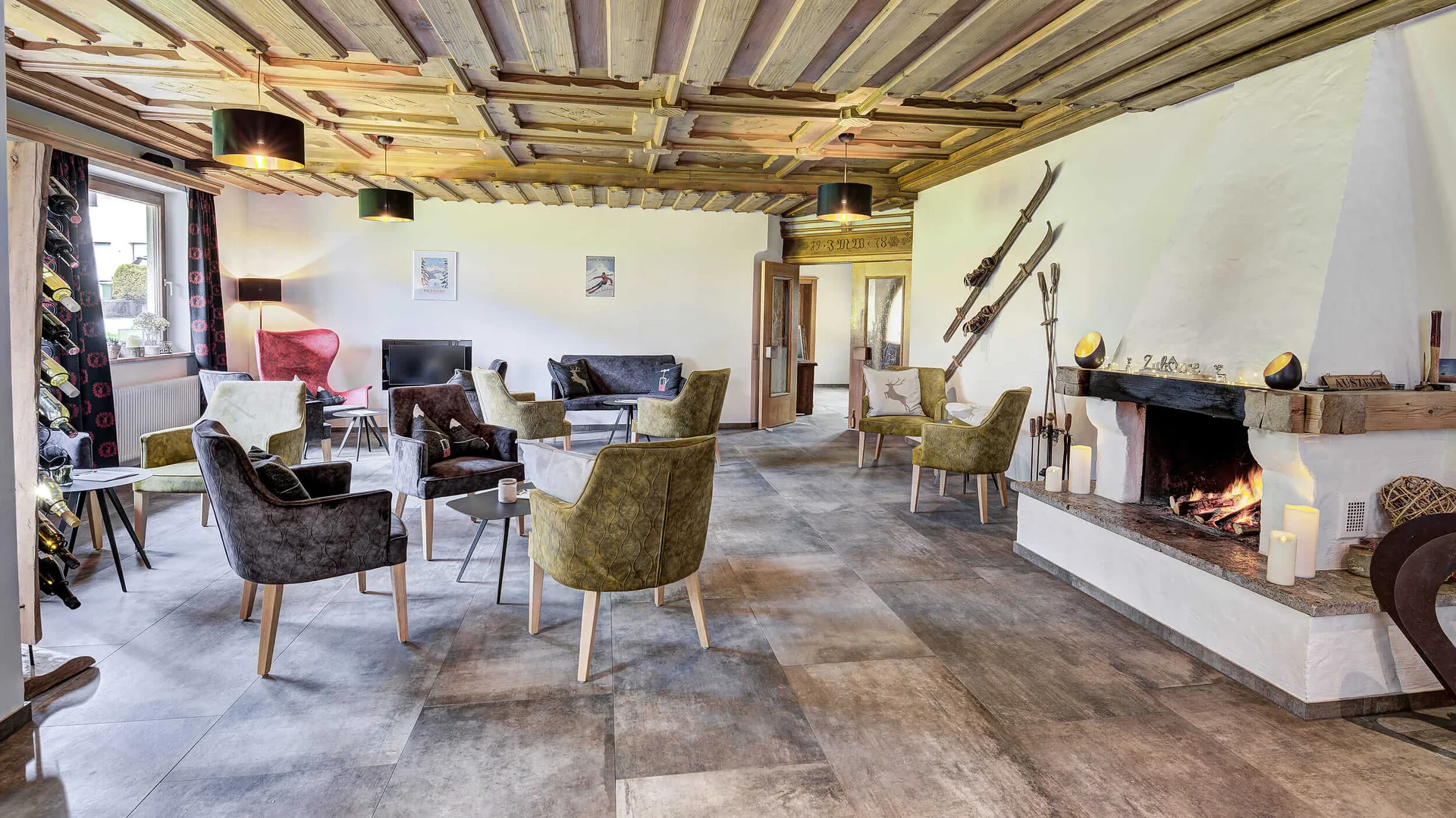 Cozy lounge area with fireplace and modern armchairs under wooden ceiling