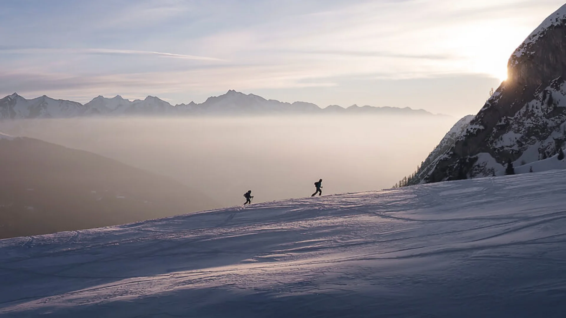 Skitouren Urlaub in Ratschings © Ratschings Tourismus - Manuel Kottersteger Zwei Skifahrer auf verschneitem Berg bei Sonnenuntergang