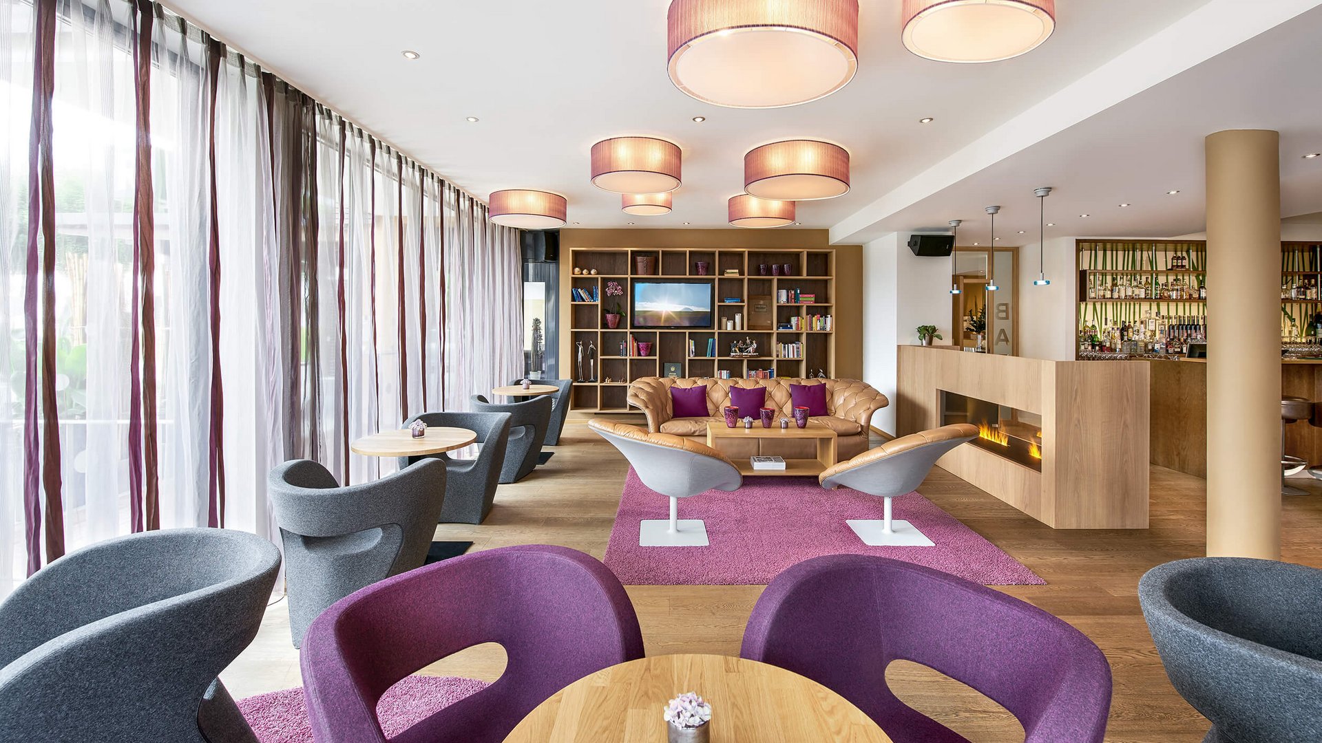 Modern hotel lounge with comfortable chairs, sofa, and fireplace