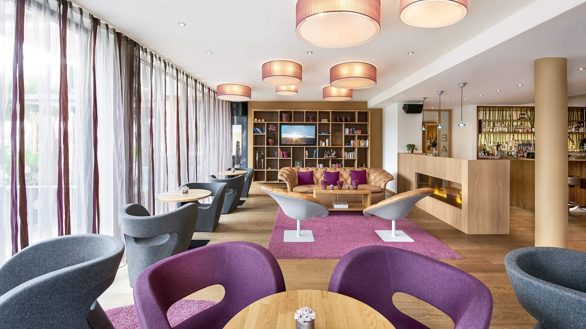 Moderner Hotel-Lounge-Bereich mit bequemen Stühlen, Sofa und Kamin