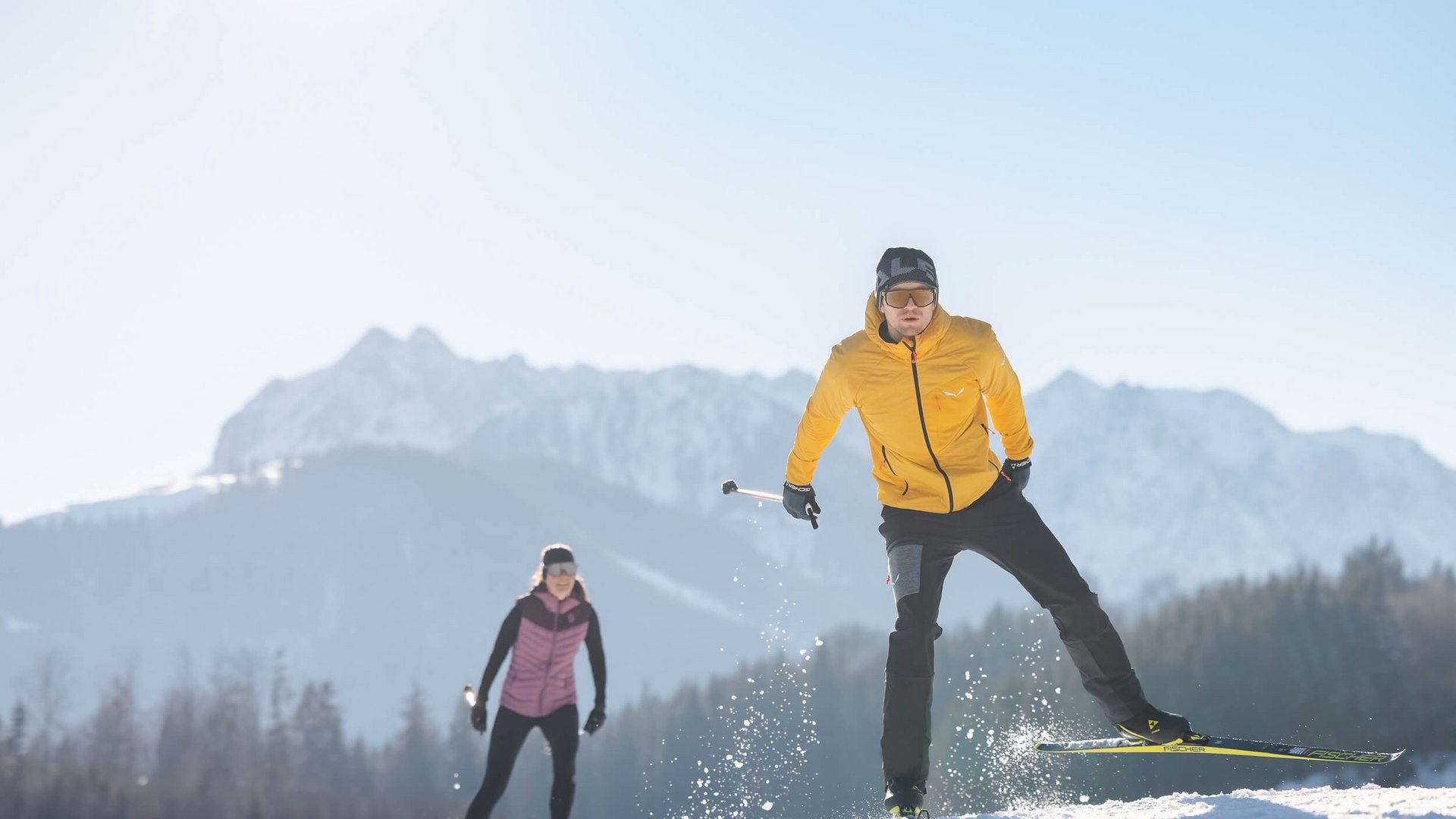 Das Walchsee Resort **** © Mathäus Gartner Zwei Langläufer auf schneebedecktem Feld vor Bergkulisse bei Sonnenschein