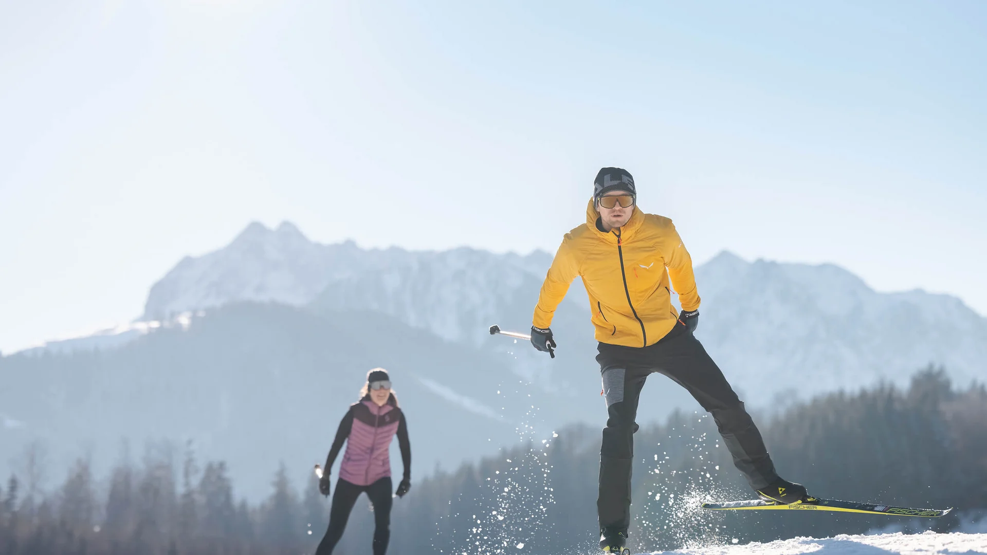The Walchsee Resort **** © Mathäus Gartner Two cross-country skiers on snow with mountain background in sunny weather