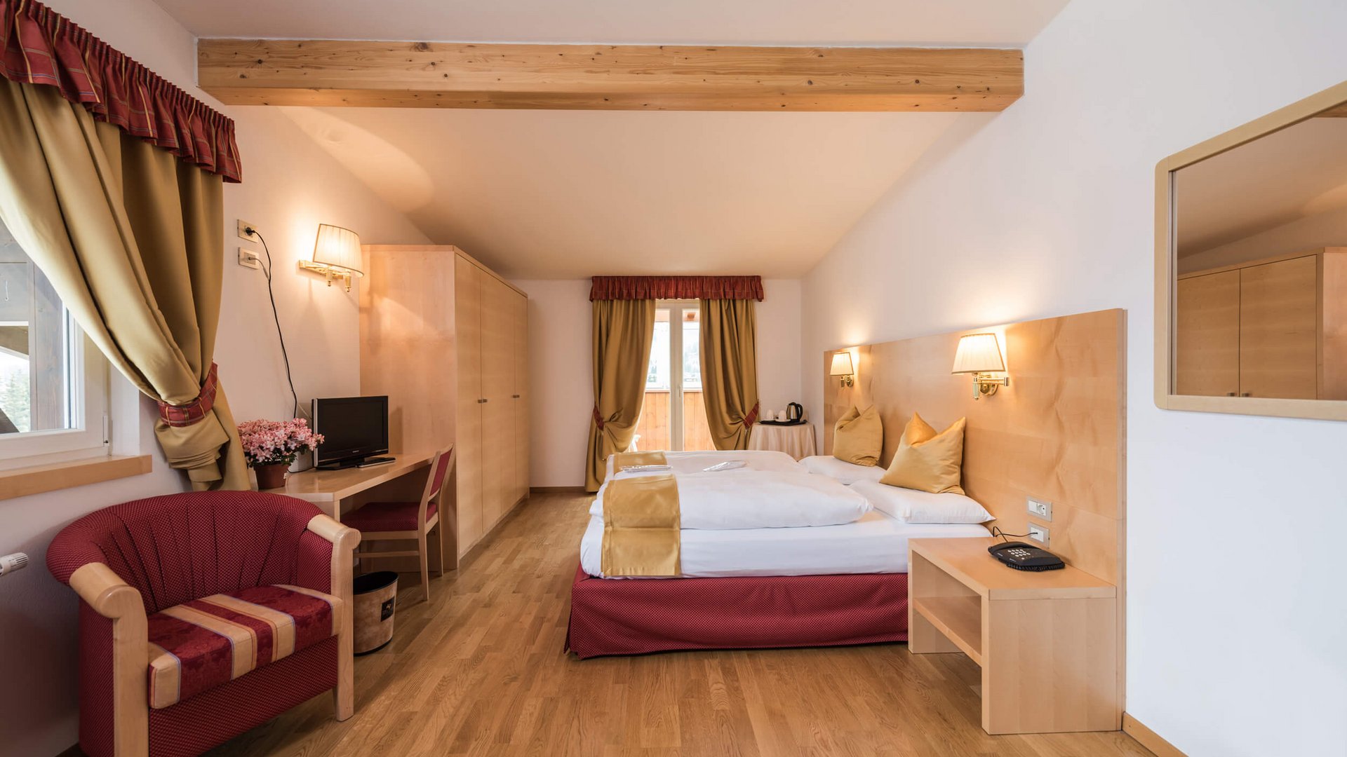 Gemütliches Hotelzimmer mit Doppelbett, Schreibtisch und Balkon