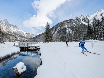 Dolomitenregion Kronplatz © Harald Wisthaler Langläufer unterwegs auf verschneiter Winterlandschaft mit Bergen und Wald