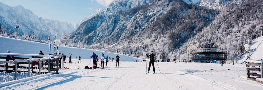Langläufer auf verschneiter Piste mit Bergen im Hintergrund