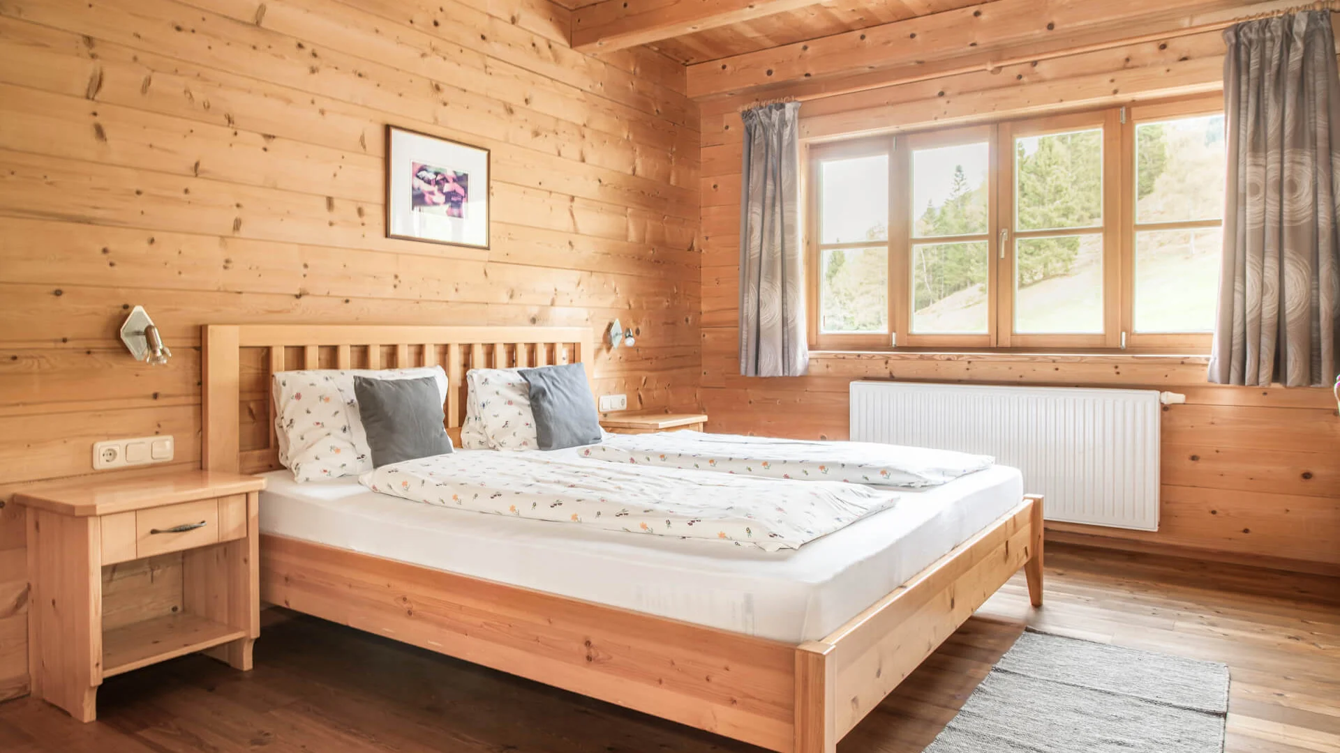Bauerndörfl Rindereben © Bernd Suppan Cozy bedroom with wooden furniture and large window with curtains