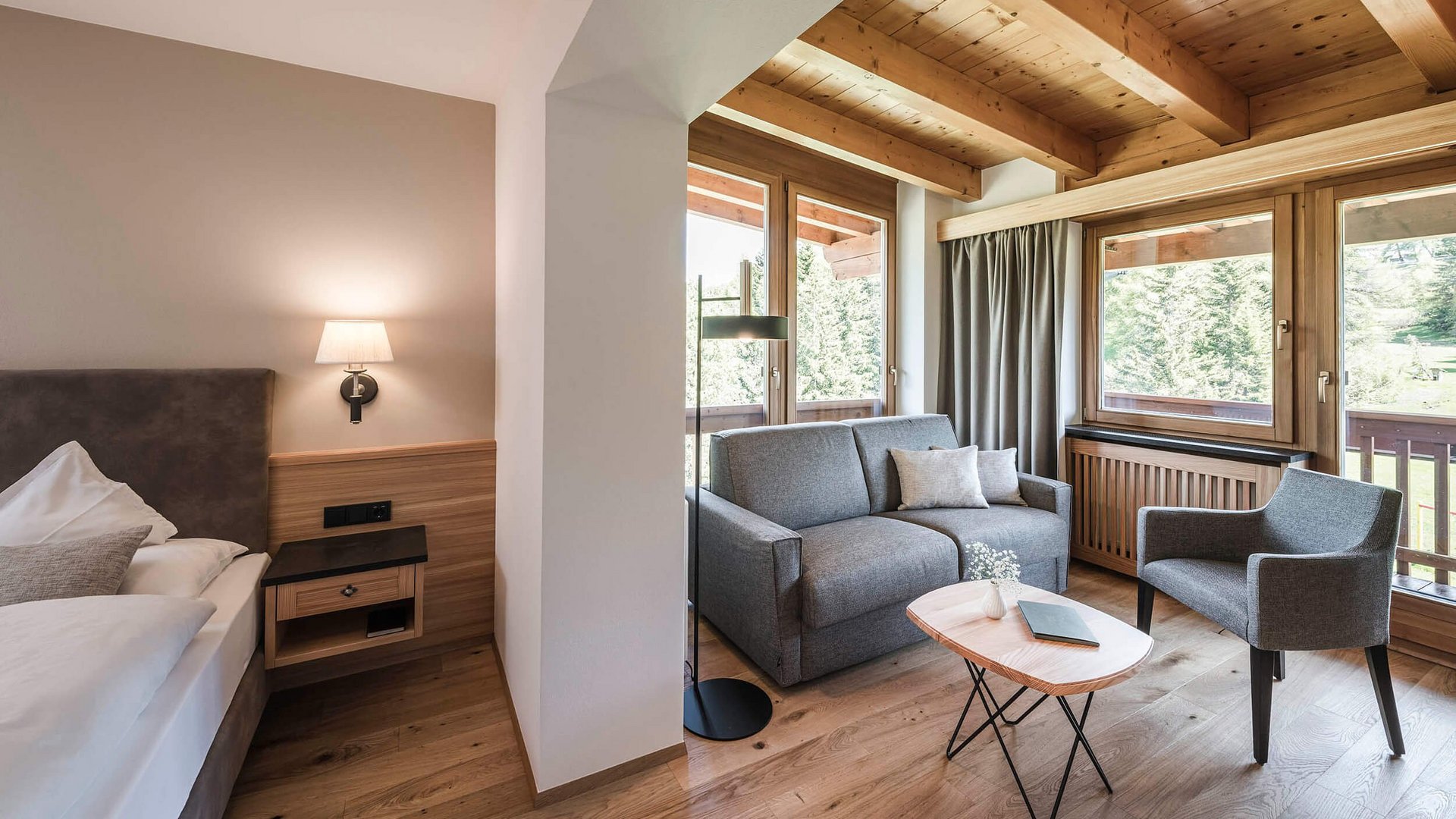 Gemütliches Hotelzimmer mit Doppelbett, Sitzbereich und großem Fenster mit Bergblick