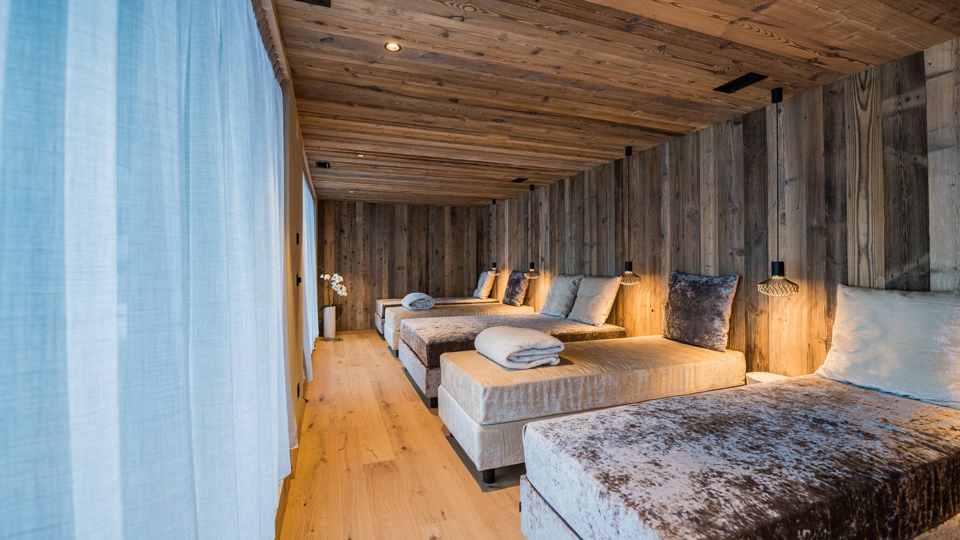 Gemütlicher Ruheraum mit samtigen Liegen und Holzwänden