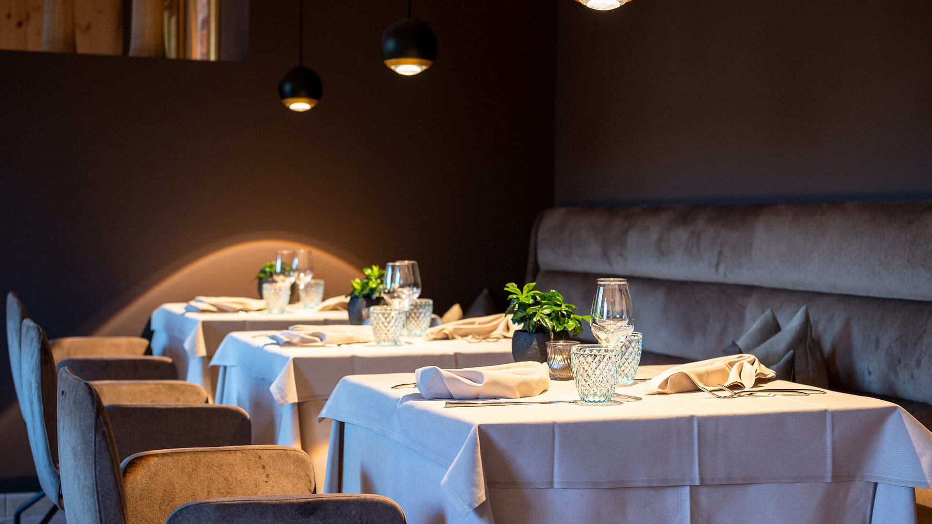 Elegantes Restaurant mit gedeckten Tischen und gedämpfter Beleuchtung